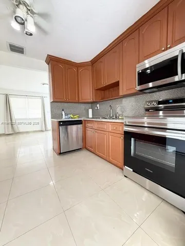 a kitchen with stainless steel appliances granite countertop a sink and a stove
