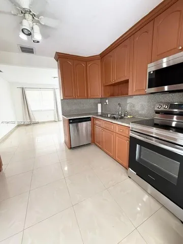 a kitchen with stainless steel appliances granite countertop a sink and a stove