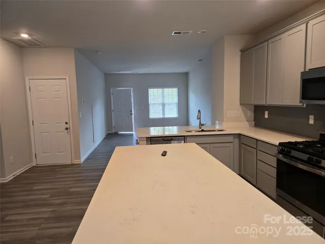 a large white kitchen with wooden floor