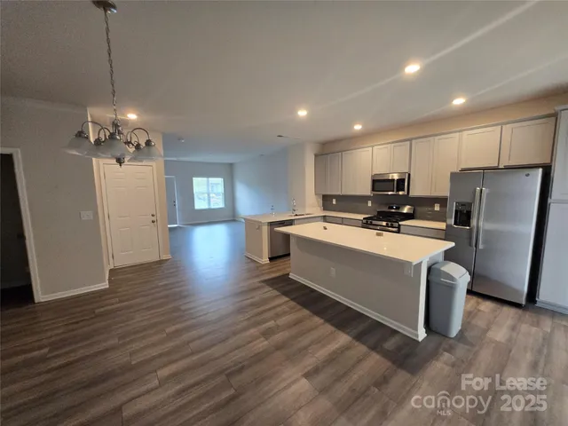 a view of a kitchen with sink stainless steel appliances and wooden floor
