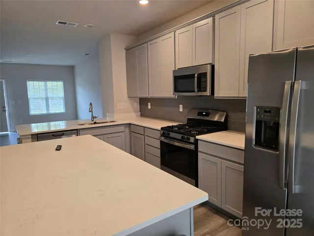 a kitchen with stainless steel appliances a refrigerator sink and stove