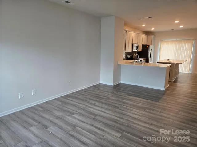 a view of kitchen view wooden floor cabinets and stainless steel appliances