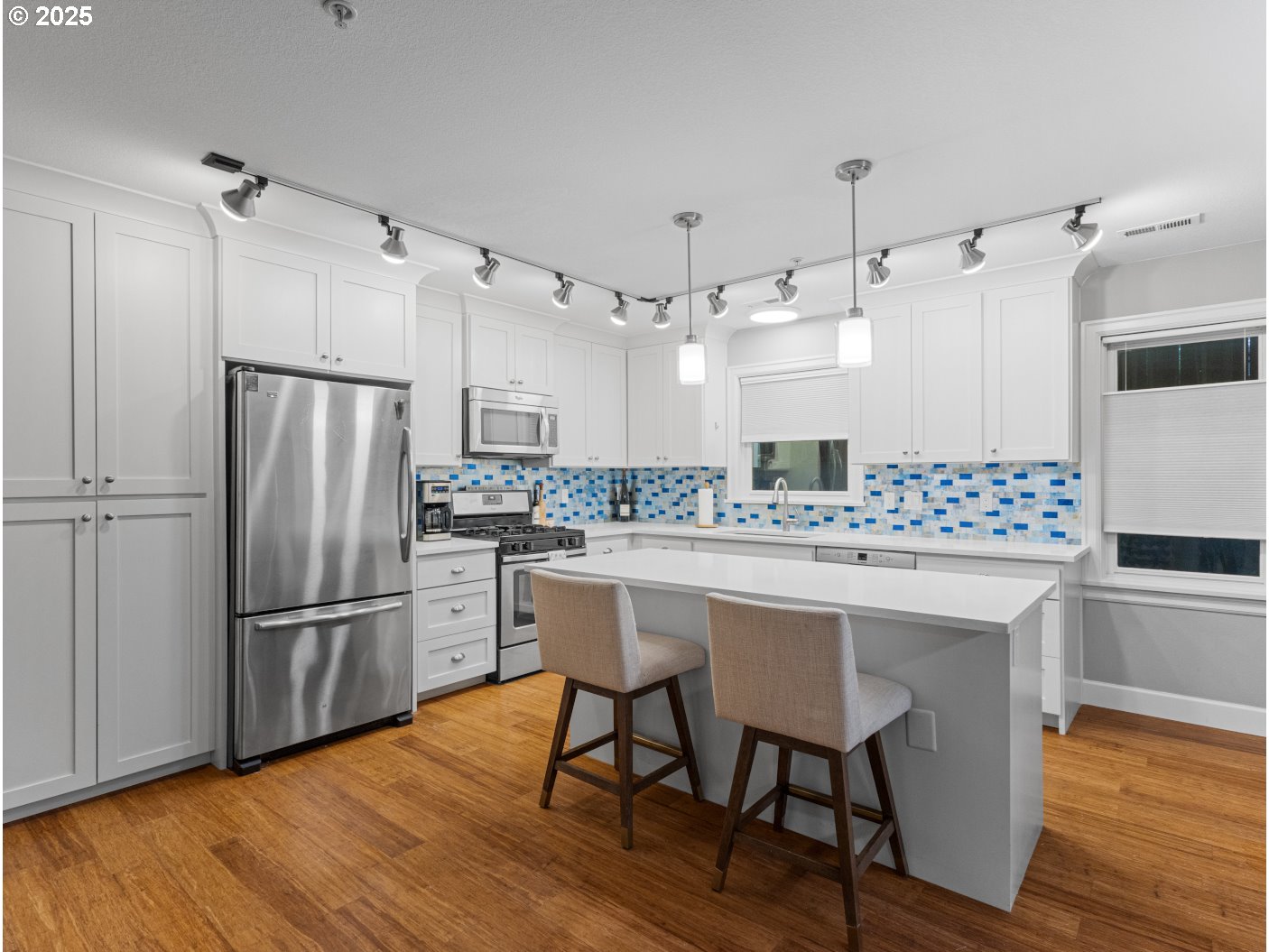 2013 Northeast 10th Avenue, Unit E Portland, OR 97212 - Photo 16 of 30 a kitchen with kitchen island white cabinets and stainless steel appliances