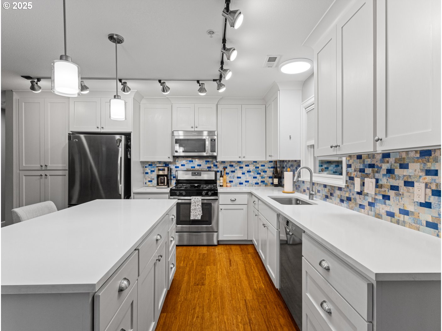 2013 Northeast 10th Avenue, Unit E Portland, OR 97212 - Photo 17 of 30 a kitchen with kitchen island a sink a counter space stainless steel appliances and cabinets