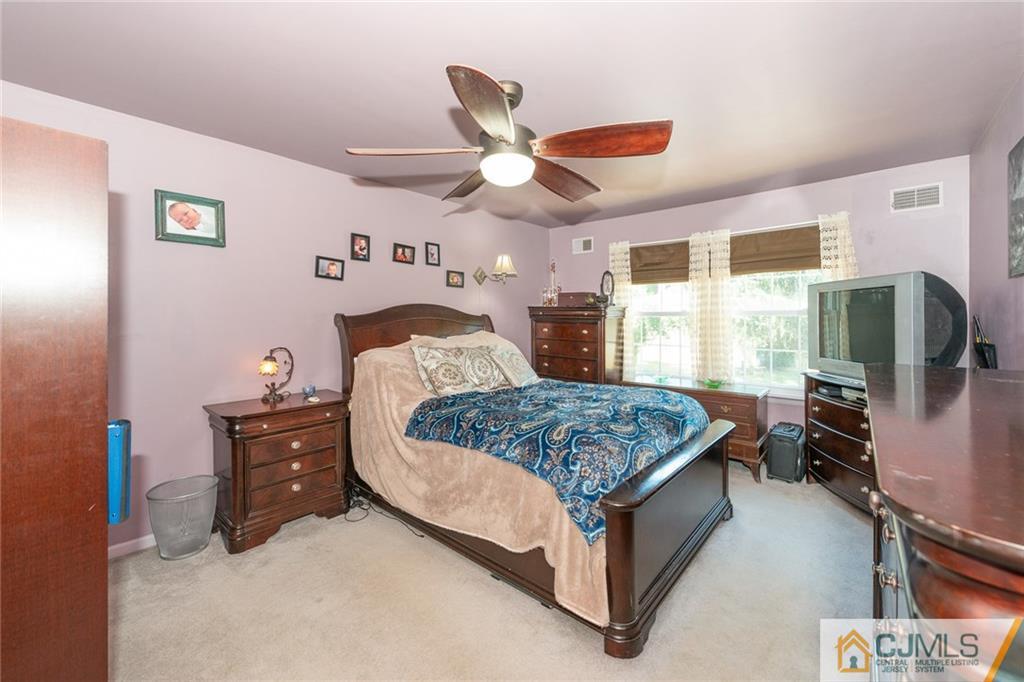 36 Hanover Square, Unit E Middlesex, NJ 08846 - Photo 12 of 23 a bedroom with a bed dresser and a flat screen tv