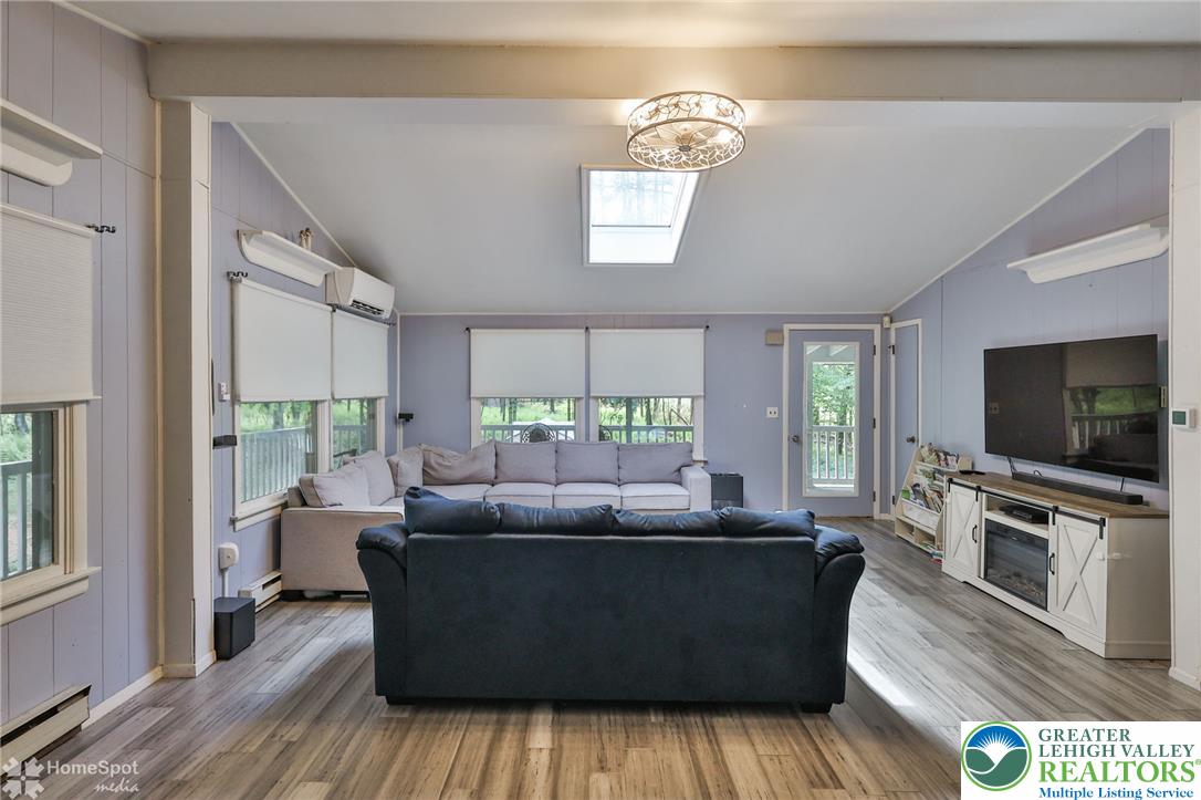 60 Sassafras Road Lehighton, PA 18235 - Photo 21 of 36 Natural light floods this living area through a skylight and numerous windows, featuring durable hardwood flooring.