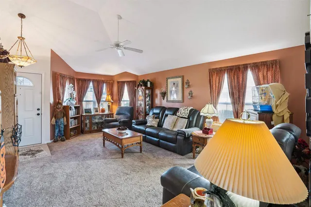 a living room with furniture fireplace and a large window
