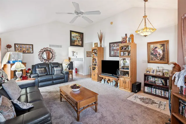 a living room with furniture a flat screen tv and paintings on the wall