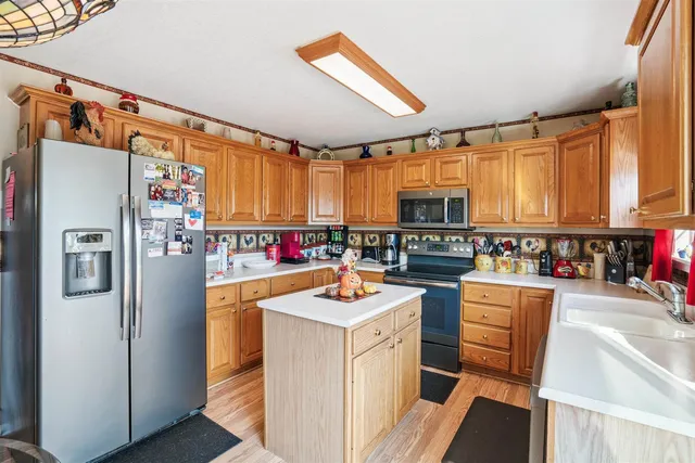 a kitchen with stainless steel appliances granite countertop a refrigerator and a stove top oven