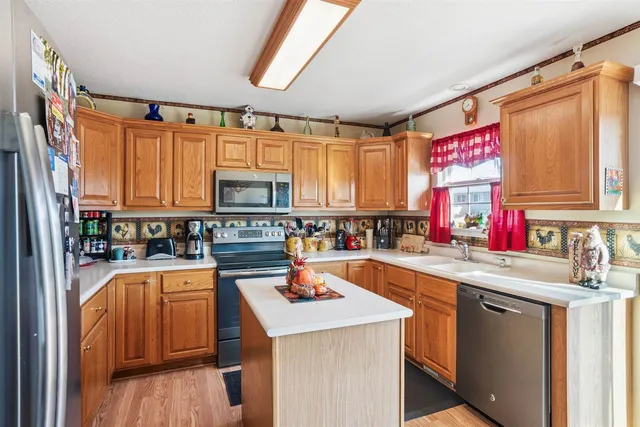 a kitchen with a sink appliances cabinets and a window