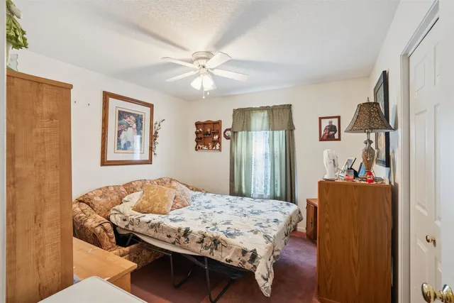 a bedroom with a bed and ceiling fan