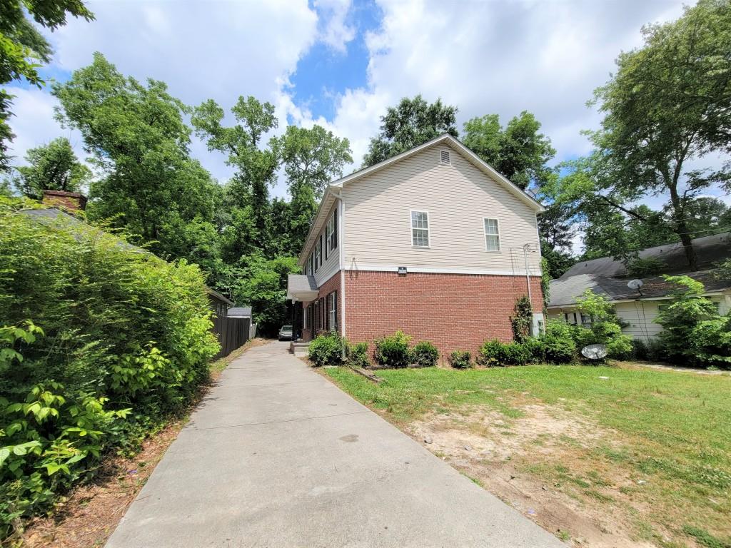978 Sims Avenue Northwest Atlanta, GA 30318 - Photo 1 of 1 a view of a house with a small yard and large trees