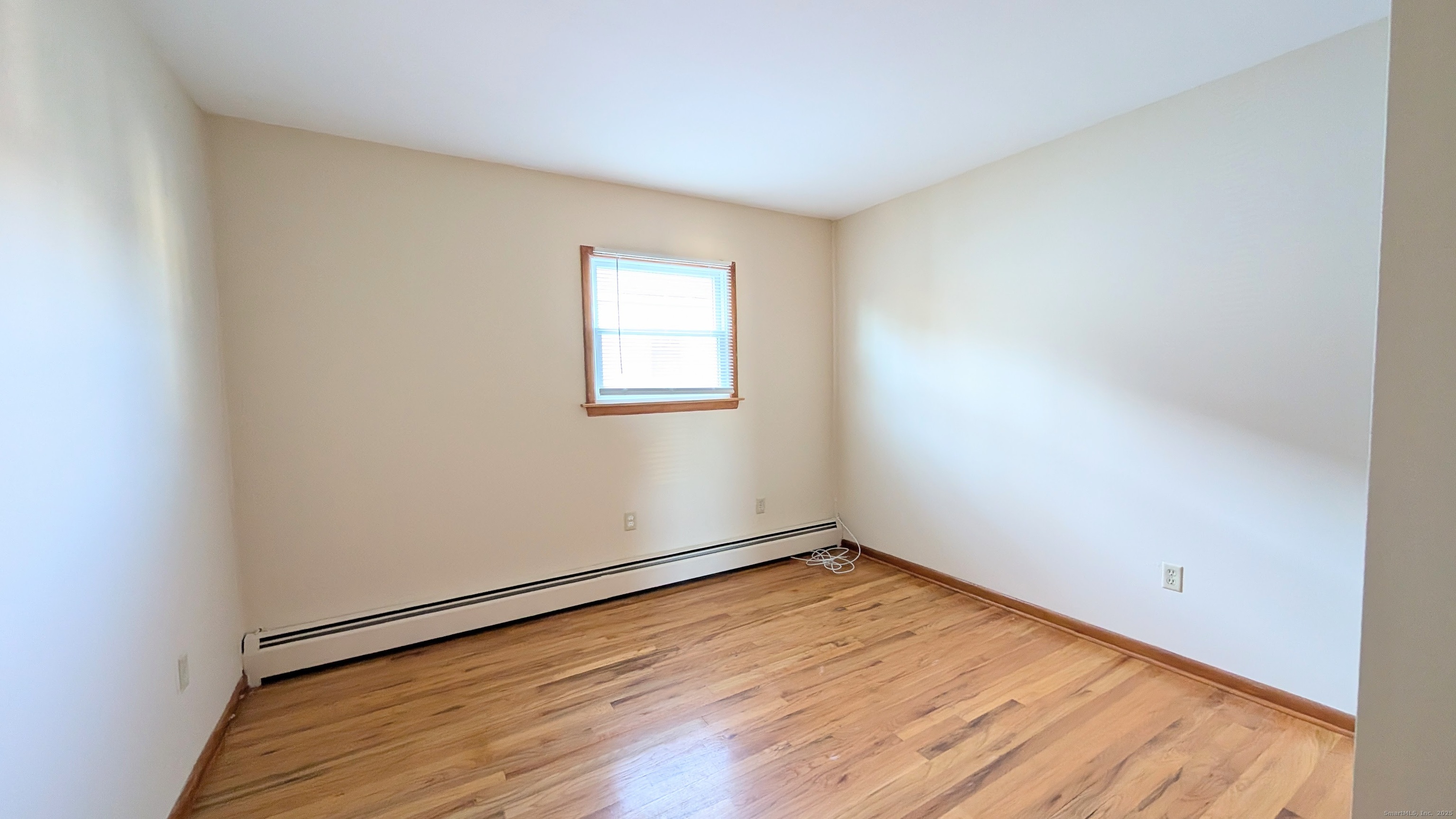 24 Hoyt Street, Unit 2 Danbury, CT 06810 - Photo 17 of 20 an empty room with wooden floor and windows