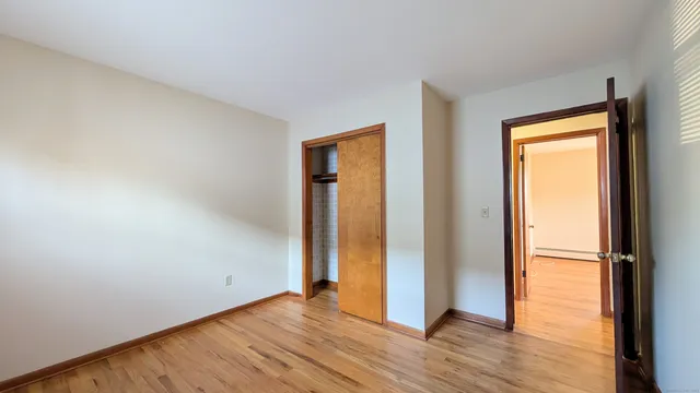 an empty room with wooden floor and a window