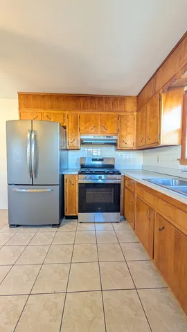 a kitchen with stainless steel appliances granite countertop a sink and a refrigerator