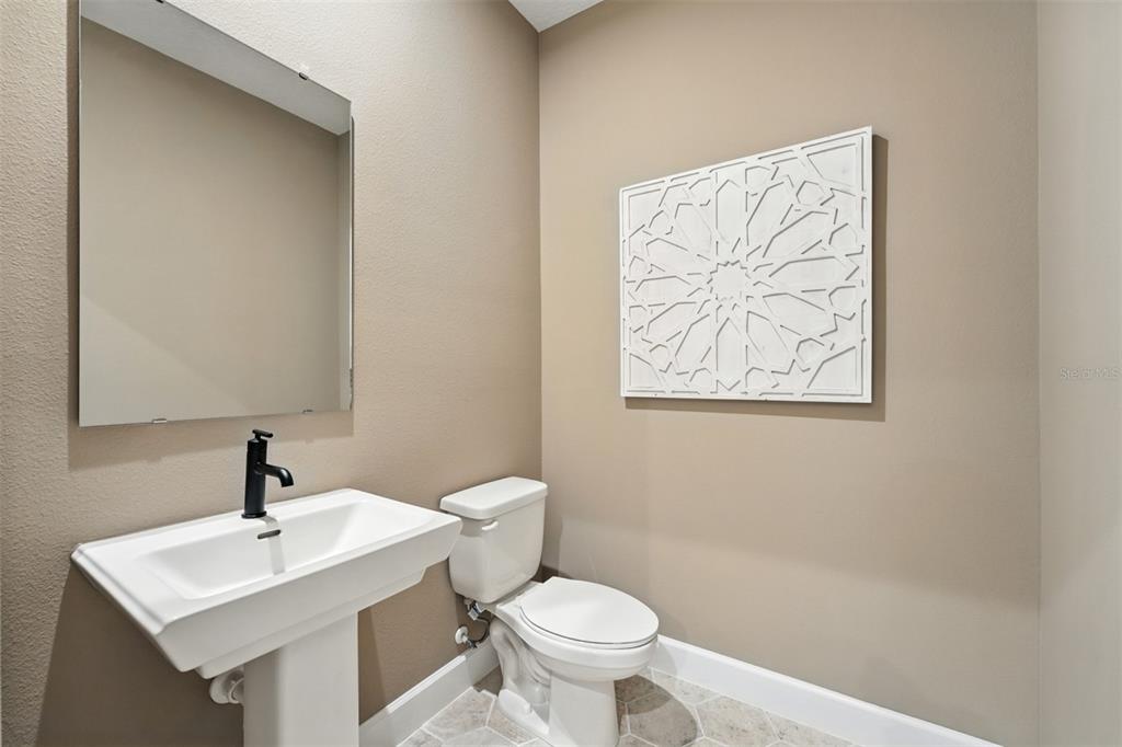1752 Headland Loop Celebration, FL 34747 - Photo 14 of 31 a bathroom with a toilet a sink and mirror