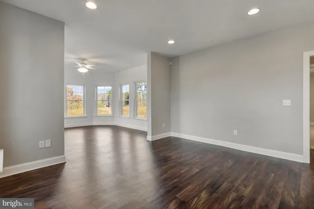 an empty room with a ceiling fan and a window