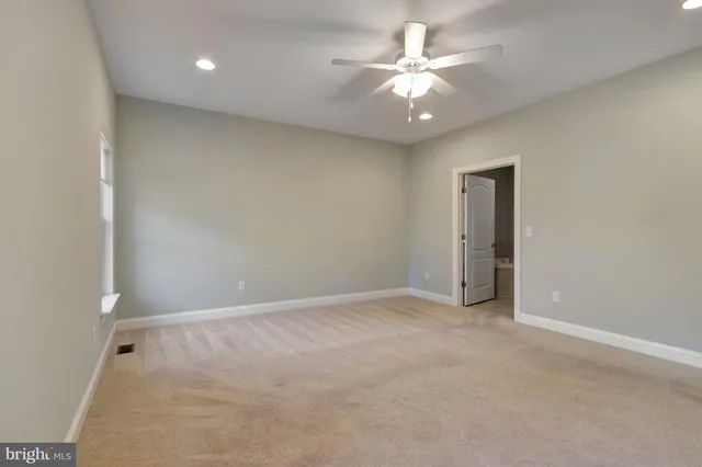 an empty room with closet and a chandelier fan