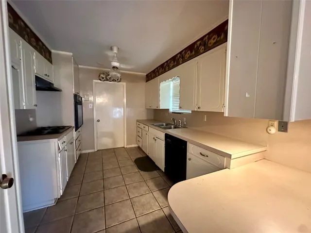 a kitchen with a sink a counter top space stainless steel appliances and cabinets