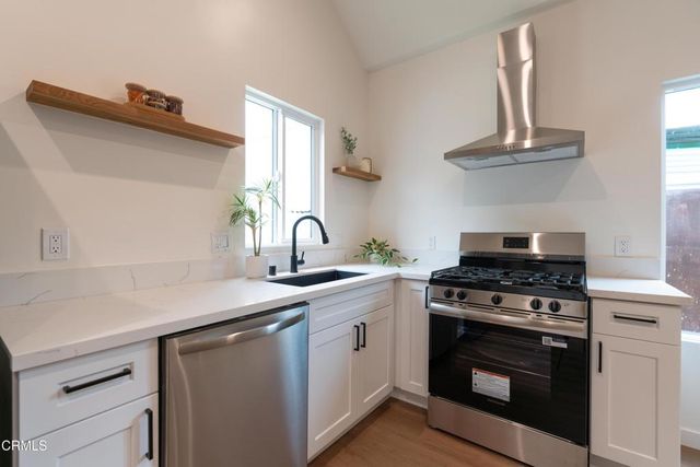a kitchen with a stove and white cabinets