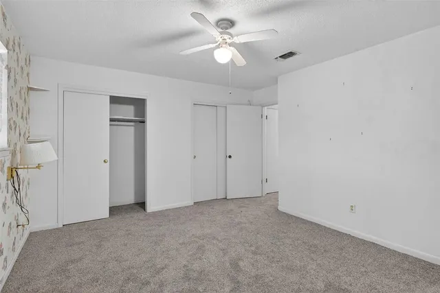 a bathroom with a granite countertop toilet a sink and a mirror