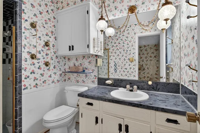 a bathroom with a granite countertop sink a mirror and shower