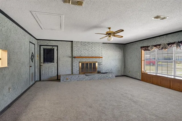 an empty room with windows and ceiling fan