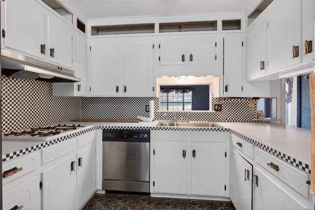 a kitchen with stainless steel appliances a stove and a microwave