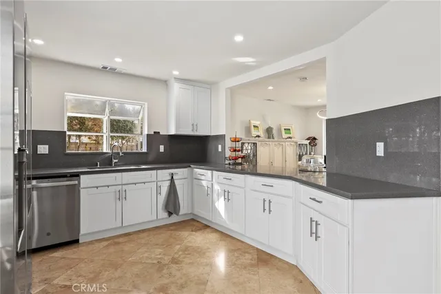 a kitchen with granite countertop white cabinets and white appliances