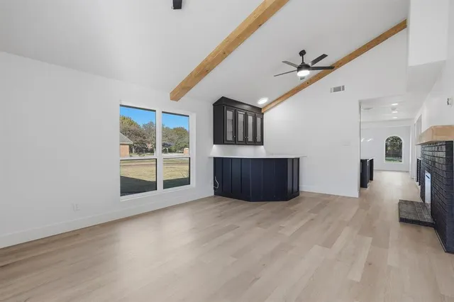 a view of an empty room with a window and a fireplace