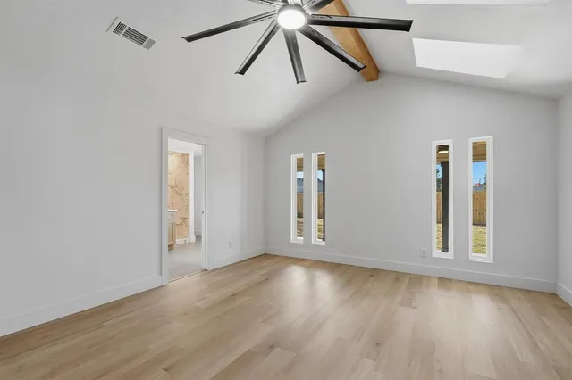 a view of a big room with wooden floor and windows