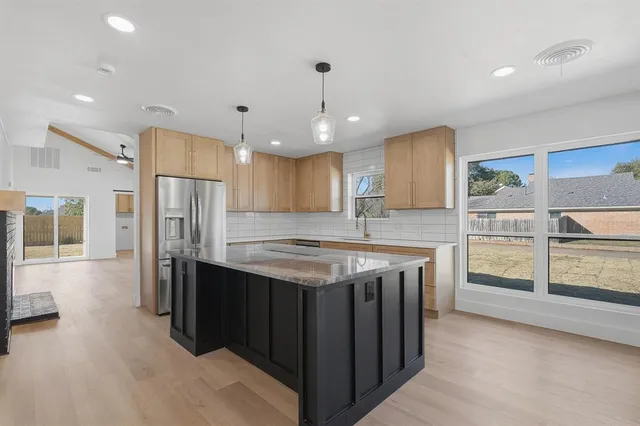 a kitchen with stainless steel appliances granite countertop a stove and a refrigerator