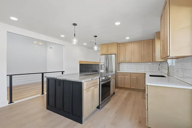 a large white kitchen with wooden floors and a fireplace