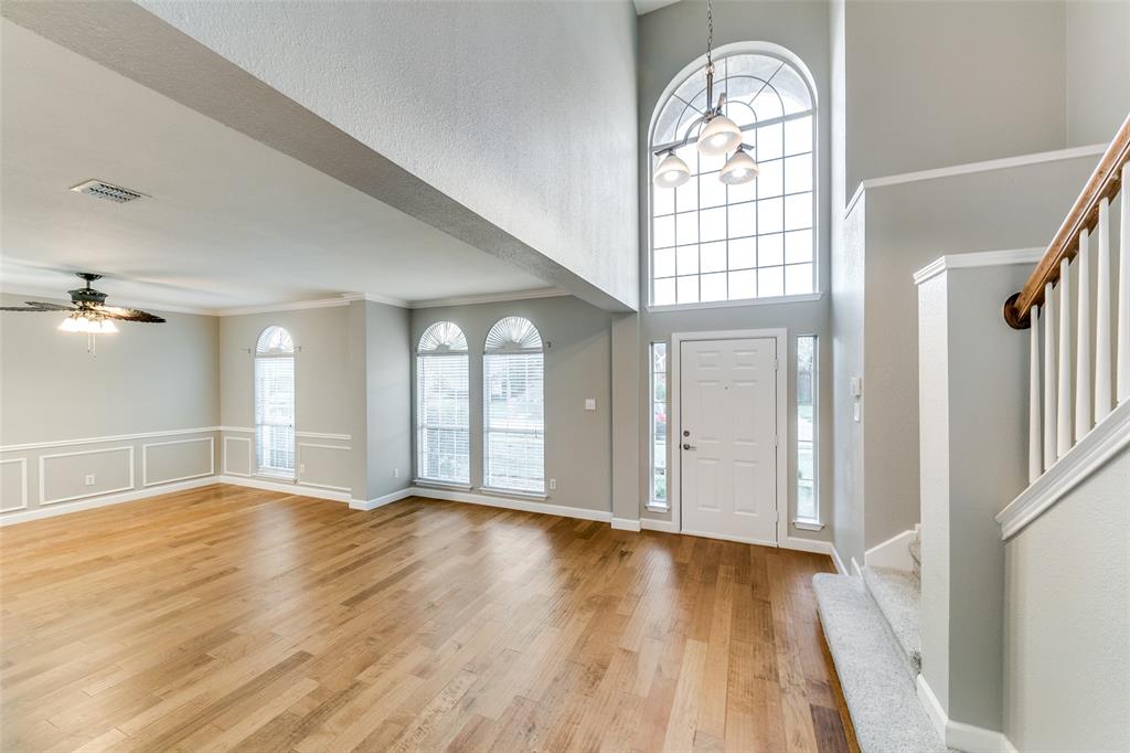 4532 Crown Ridge Drive Plano, TX 75024 - Photo 2 of 25 Two-story foyer with an arched window, wood-finish flooring, and a modern chandelier