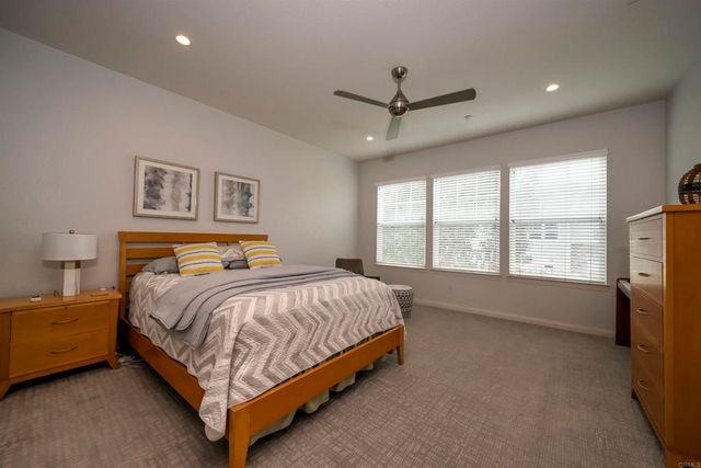 a bed sitting in a spacious bedroom next to a window