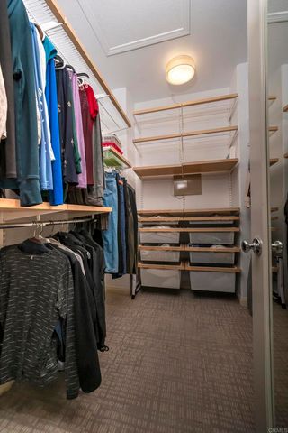 a view of walk in closet with clothes and shoes