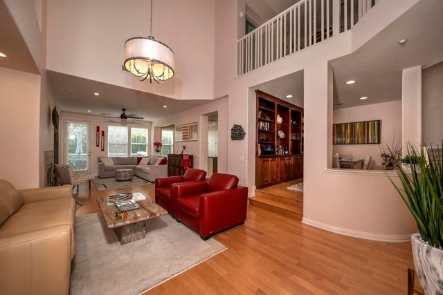 a living room with furniture and a large mirror with a wooden floor