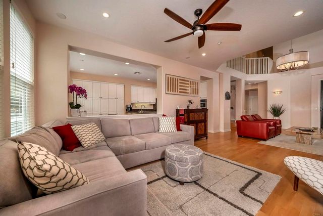 a living room with furniture kitchen view and a window