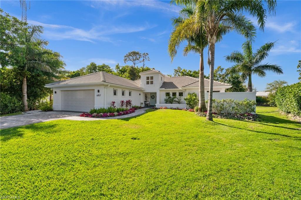 6857 Mill Run Road Naples, FL 34109 - Photo 1 of 49 Mediterranean / spanish-style house featuring driveway, a tile roof, an attached garage, a front yard, and stucco siding