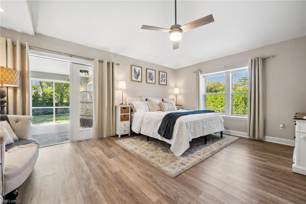 6857 Mill Run Road Naples, FL 34109 - Photo 16 of 49 Bedroom featuring access to exterior, a ceiling fan, vaulted ceiling, wood finished floors, and baseboards