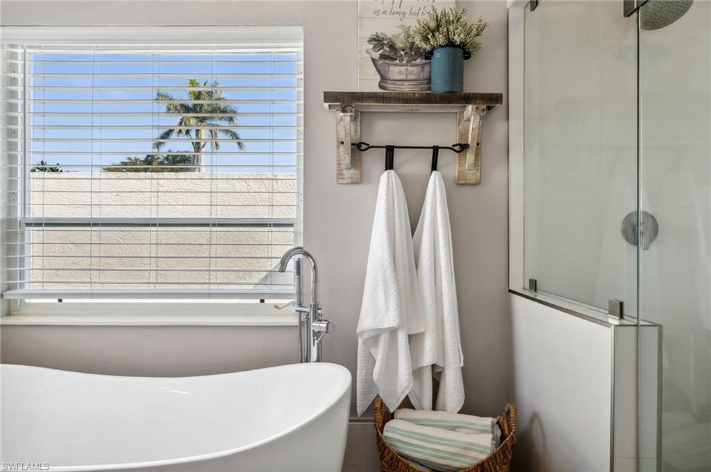 6857 Mill Run Road Naples, FL 34109 - Photo 20 of 49 Bathroom featuring a healthy amount of sunlight, a stall shower, and a soaking tub