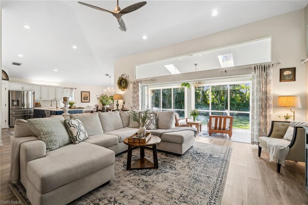 6857 Mill Run Road Naples, FL 34109 - Photo 25 of 49 Living area featuring visible vents, ceiling fan with notable chandelier, vaulted ceiling, light wood-type flooring, and recessed lighting