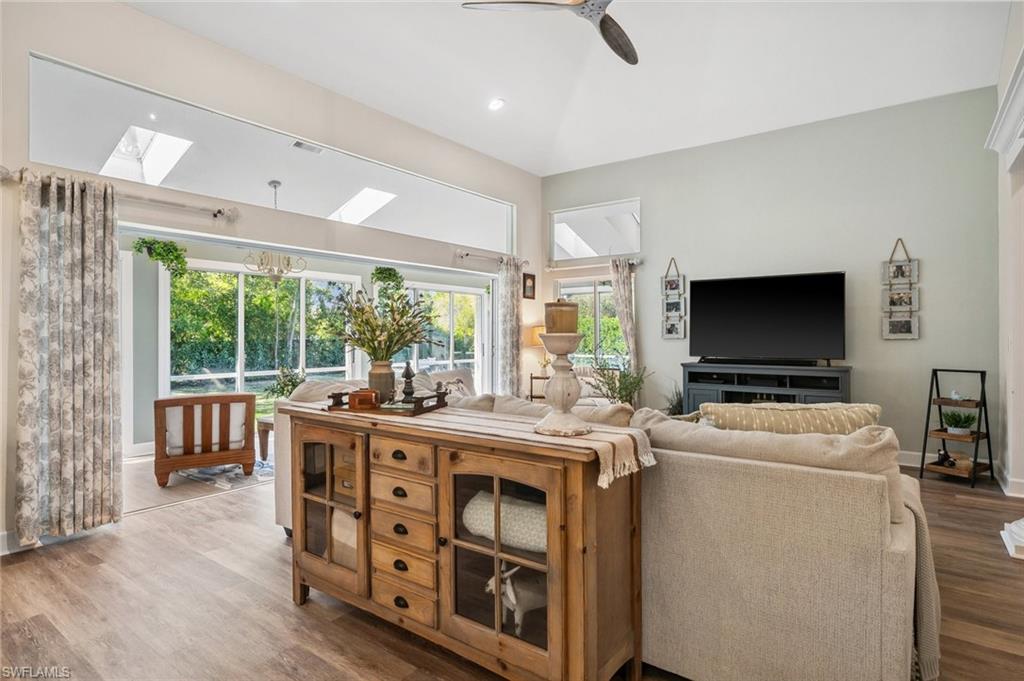 6857 Mill Run Road Naples, FL 34109 - Photo 28 of 49 Living area with visible vents, baseboards, lofted ceiling with skylight, ceiling fan, and wood finished floors