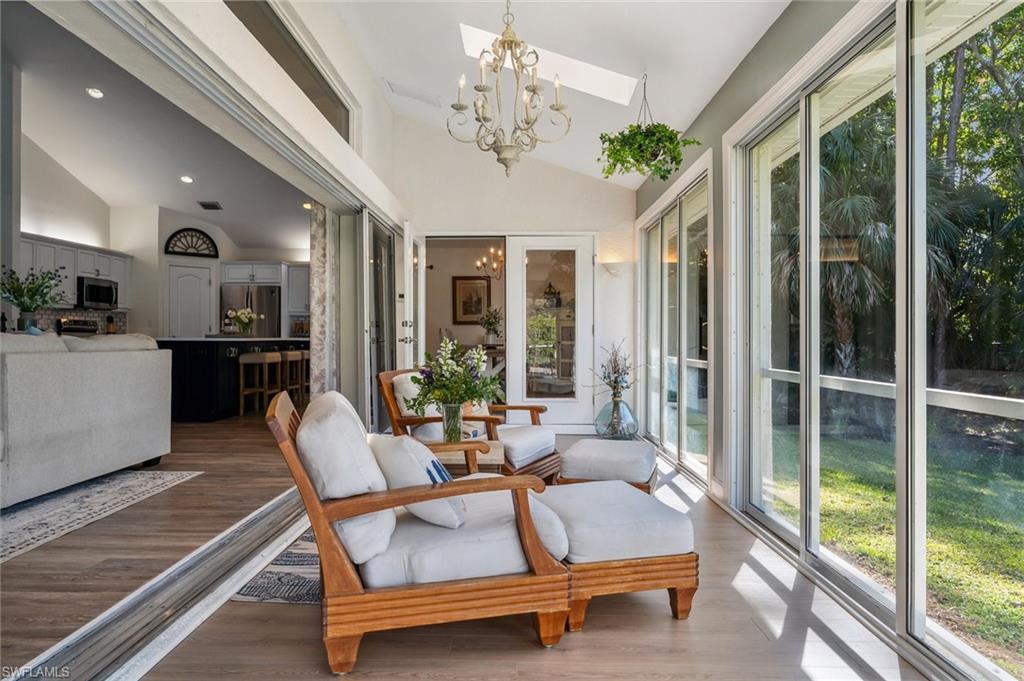 6857 Mill Run Road Naples, FL 34109 - Photo 30 of 49 Sunroom with lofted ceiling with skylight and a notable chandelier