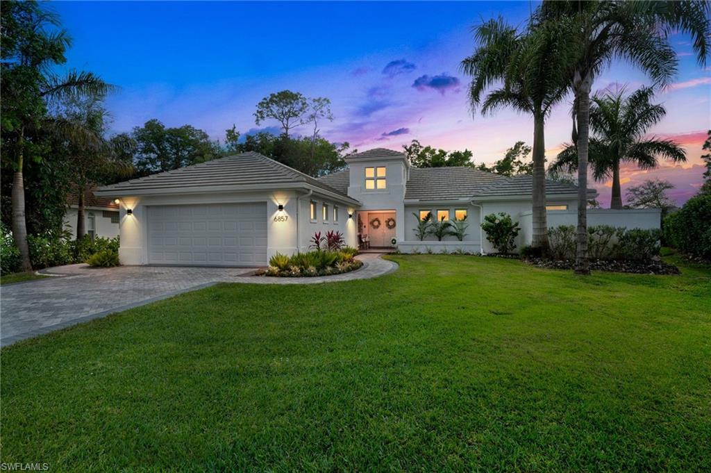 6857 Mill Run Road Naples, FL 34109 - Photo 4 of 49 View of front facade with decorative driveway, stucco siding, a lawn, an attached garage, and a tiled roof
