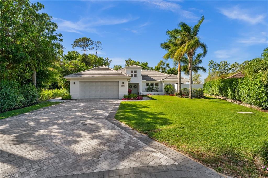 6857 Mill Run Road Naples, FL 34109 - Photo 45 of 49 View of front of house featuring a garage, a tiled roof, decorative driveway, stucco siding, and a front yard