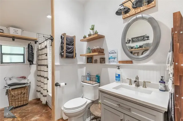a bathroom with a sink a toilet and a mirror