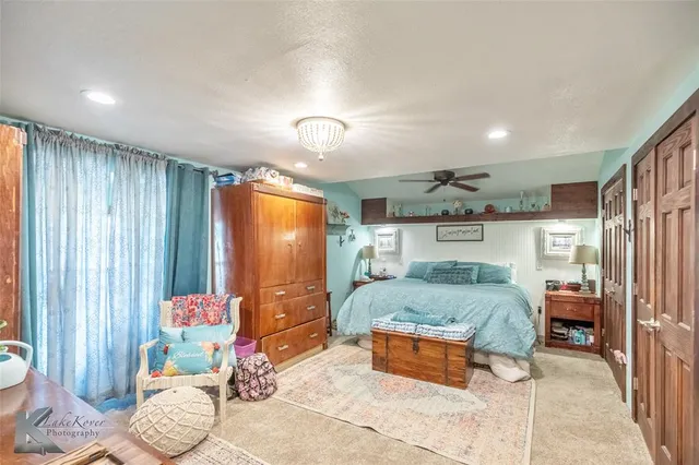 a spacious bedroom with a bed and a chandelier
