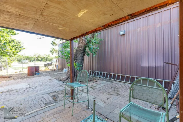 a view of a backyard with large tree and wooden fence