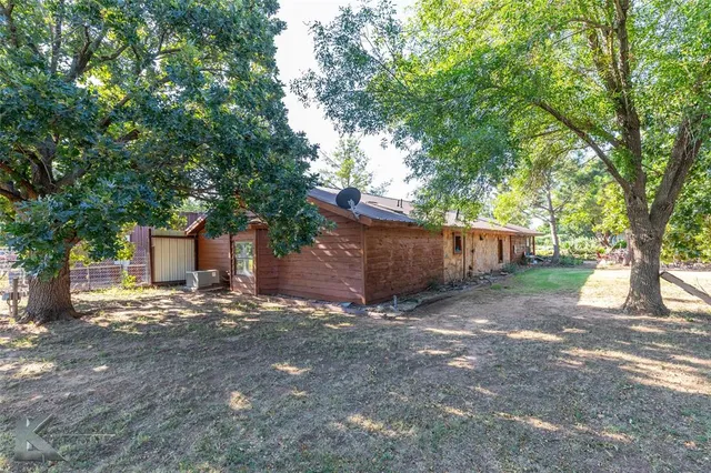 a view of a patio with table and chairs potted plants and large tree